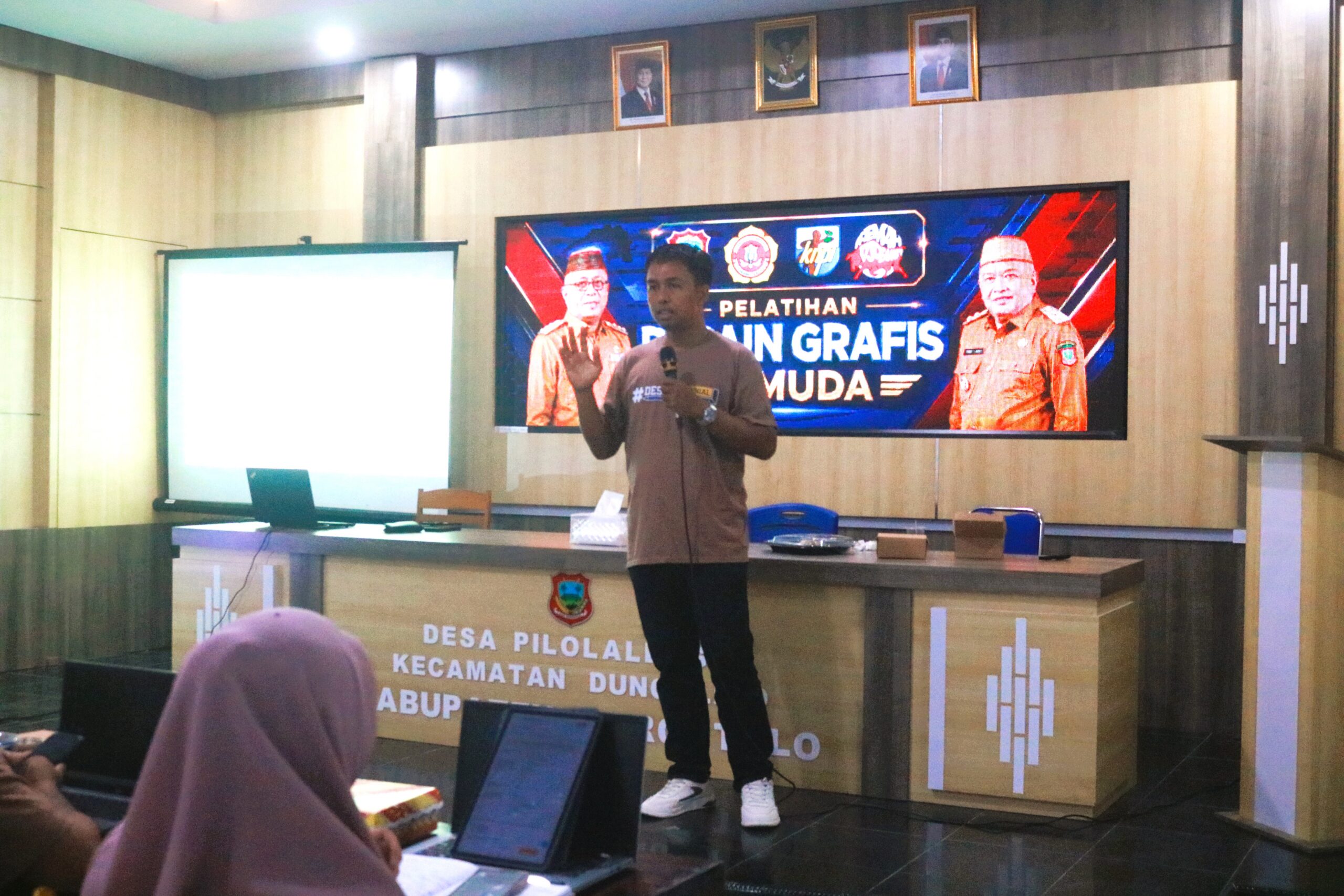 Pelatihan Desain Grafis Berbasis AI pemuda Kabupaten Gorontalo dalam menguasai teknologi desain grafis berbasis AI di Aula Kantor Desa Pilolalenga.